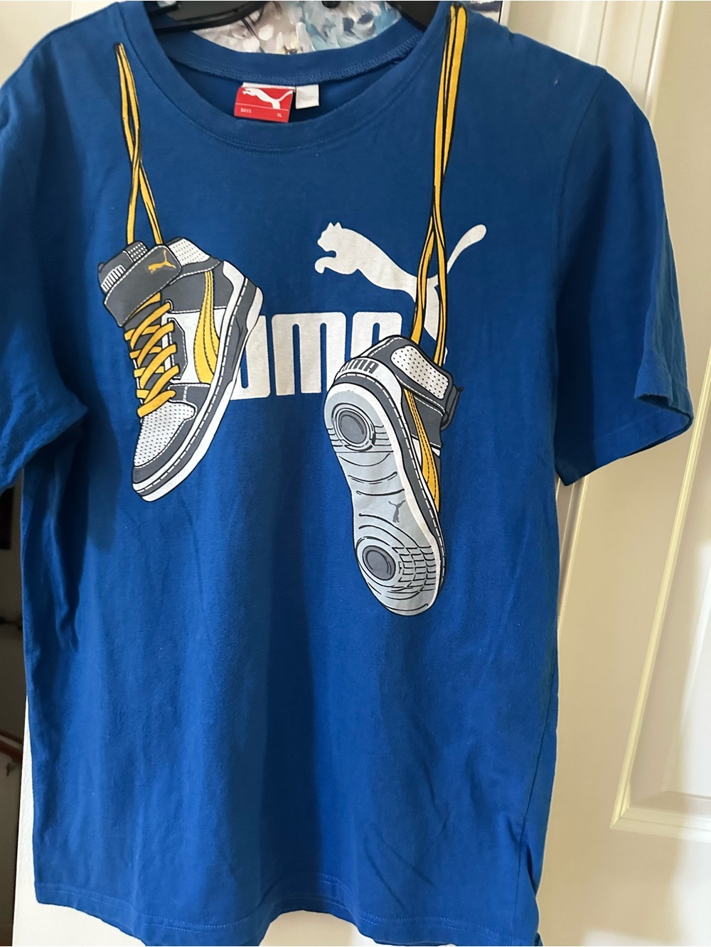 Puma Blue Tee with Hanging Sneaker Graphic and Yellow Accents